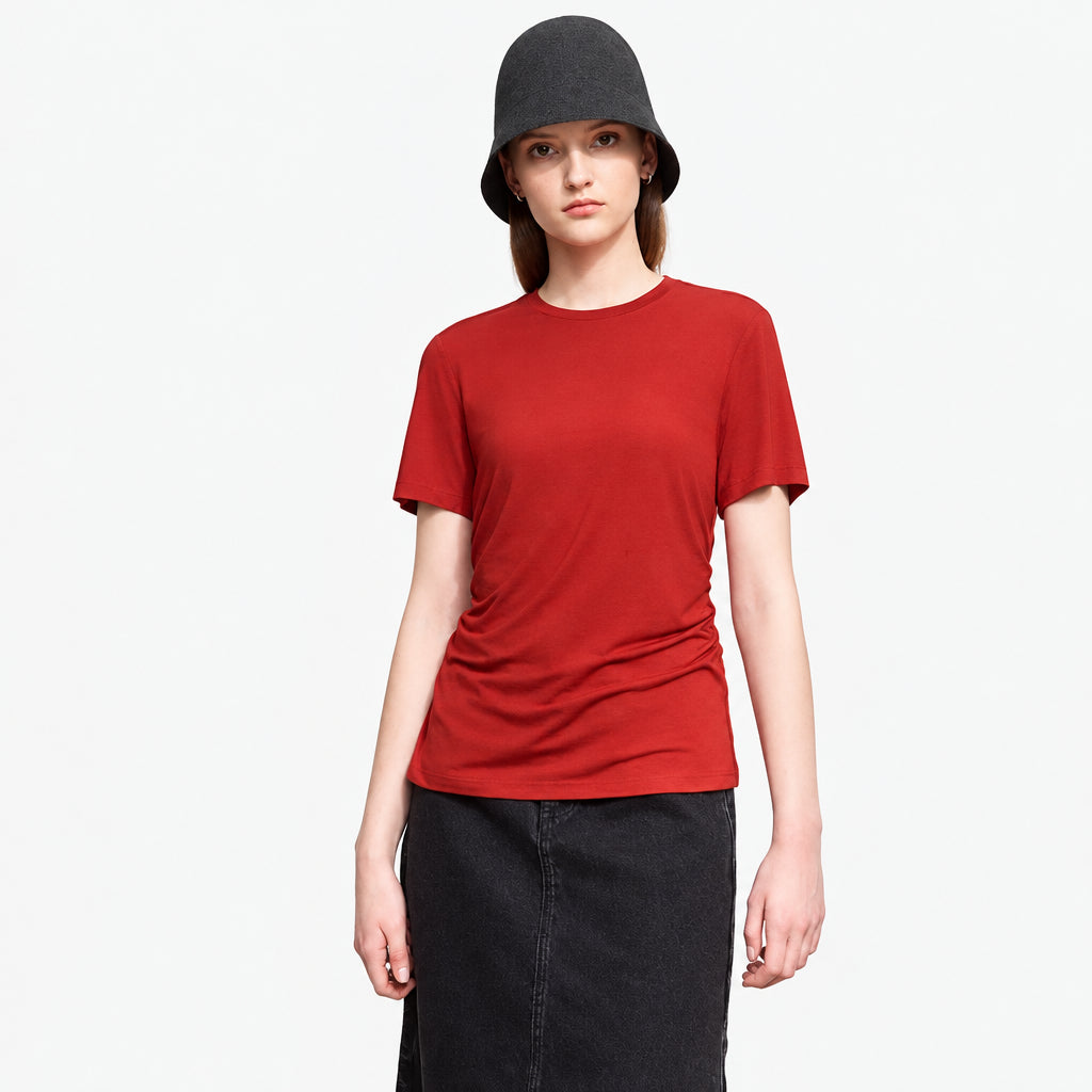 Person wearing a red t-shirt and black hat against a plain background with 'AMII' branding.